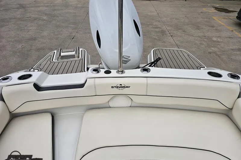 Slide: The Image of 2022 Stingray 182 SC boat interior with white seating and cup holders. - 81