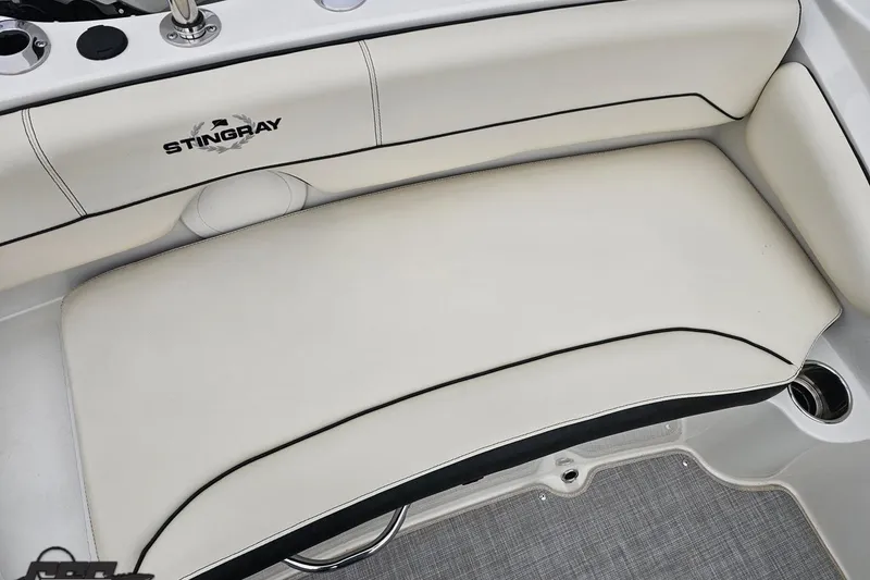 Slide: The Image of 2022 Stingray 182 SC boat interior with white cushioned seating and cup holders. - 84