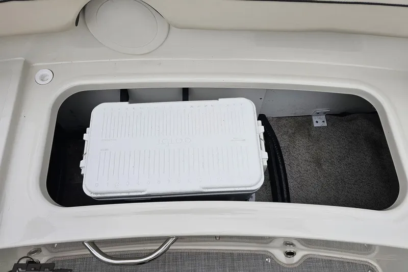 Slide: The Image of Storage compartment in 2022 Stingray 182 SC boat with white Igloo cooler. - 85