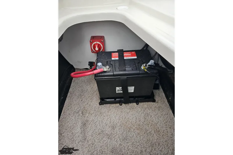 Slide: The Image of Battery compartment of 2022 Stingray 182 SC boat with red power switch. - 87