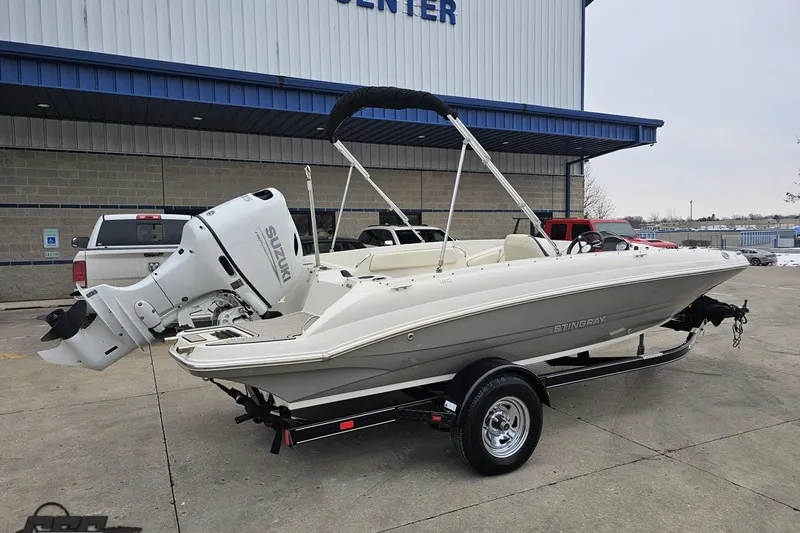 Slide: The Image of 2022 Stingray 182 SC boat with Suzuki outboard motor on trailer, parked outside. - 9