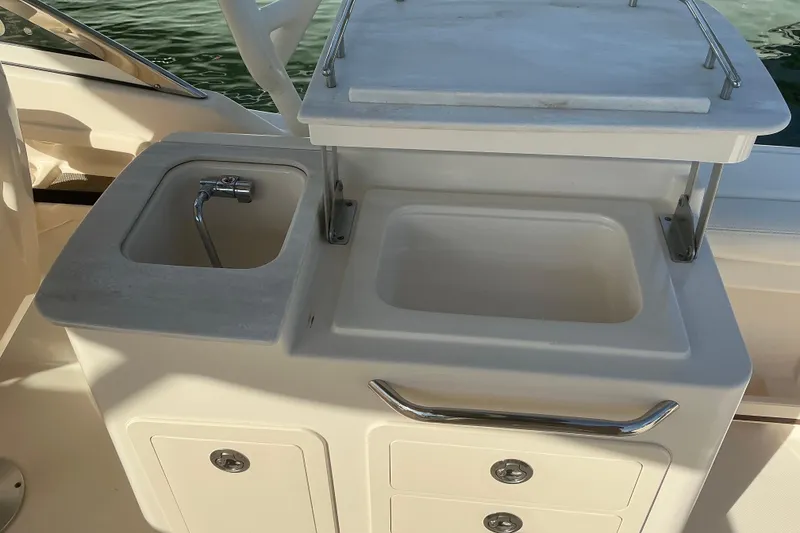 Slide: The Image of 2020 Grady-White Freedom 275 boat sink and storage area, featuring a compact design. - 6