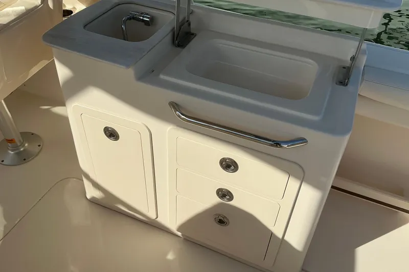 Slide: The Image of 2020 Grady-White Freedom 275 boat interior with sink and storage compartments. - 7