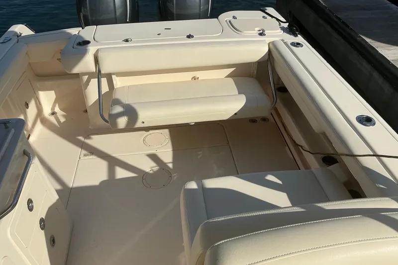 Slide: The Image of 2020 Grady-White Freedom 275 boat interior with beige seating and storage compartments. - 9