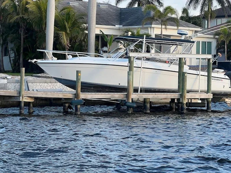 Slide: The Image of 2001 Contender 35 Side Console boat docked by waterfront home with palm trees. - 1