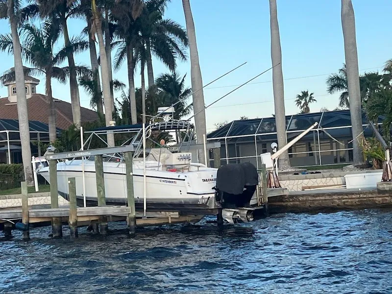 Slide: The Image of 2001 Contender 35 Side Console boat docked by waterfront homes and palm trees. - 11