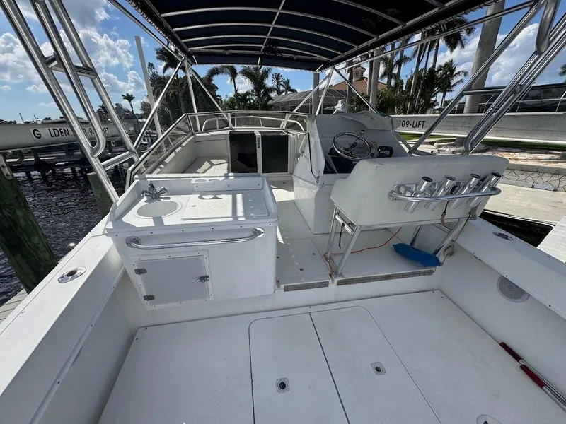 Slide: The Image of 2001 Contender 35 Side Console boat with spacious deck and seating, docked under clear skies. - 12