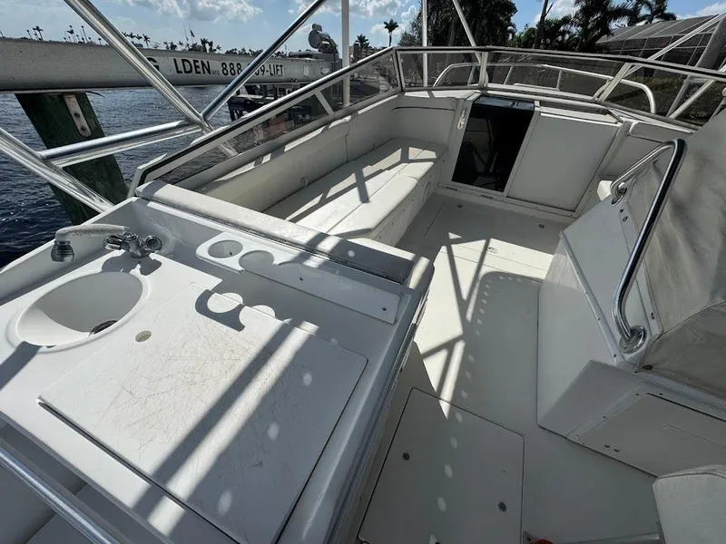 Slide: The Image of 2001 Contender 35 Side Console boat interior with seating and sink, docked by the water. - 15