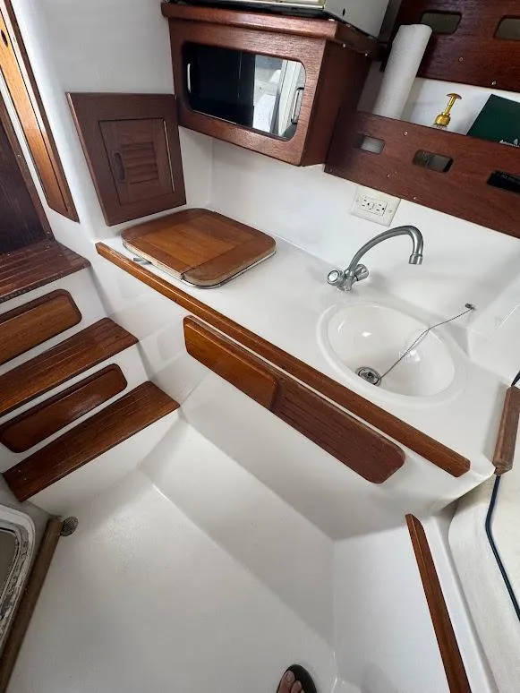 Slide: The Image of 2001 Contender 35 Side Console boat interior with sink, wooden accents, and storage. - 22