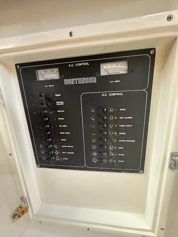 Slide: The Image of Electrical control panel of 2001 Contender 35 Side Console boat, featuring AC and DC controls. - 23