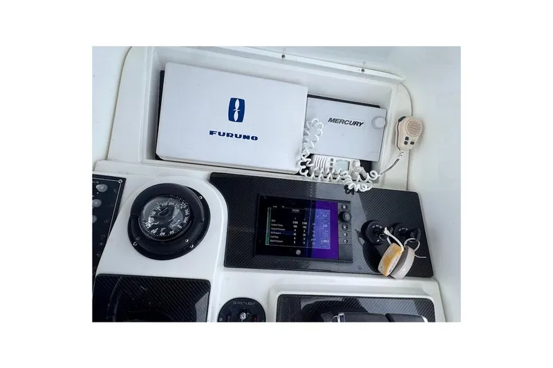 Slide: The Image of 2001 Contender 35 Side Console dashboard with Furuno and Mercury equipment. - 25