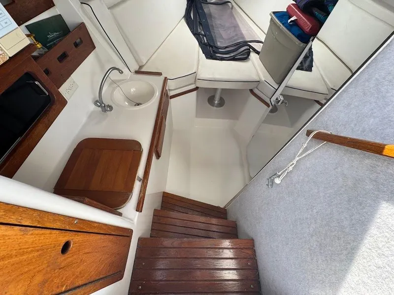 Slide: The Image of 2001 Contender 35 Side Console interior with wooden stairs and compact seating area. - 28