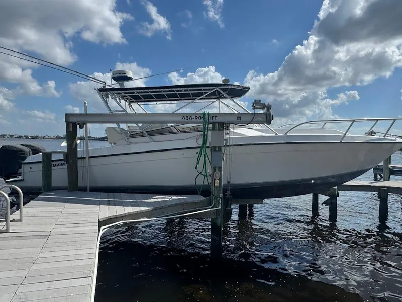 Slide: The Image of 2001 Contender 35 Side Console boat docked under a cloudy sky. - 4