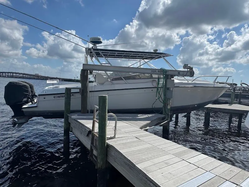 Slide: The Image of 2001 Contender 35 Side Console boat docked under a cloudy sky. - 5