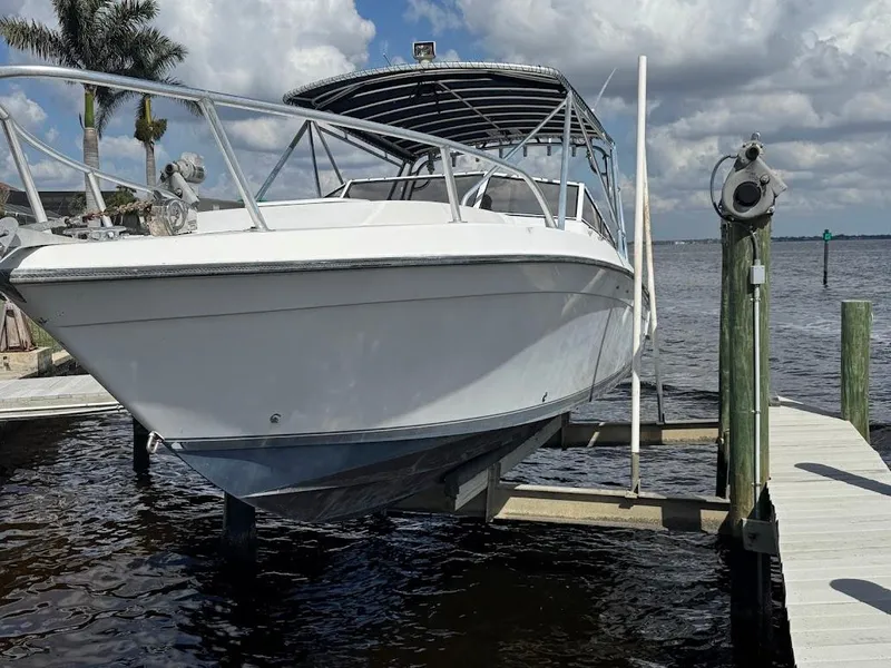 Slide: The Image of 2001 Contender 35 Side Console boat docked by a pier under a cloudy sky. - 6