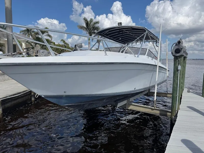 Slide: The Image of 2001 Contender 35 Side Console boat docked by the water under a cloudy sky. - 7
