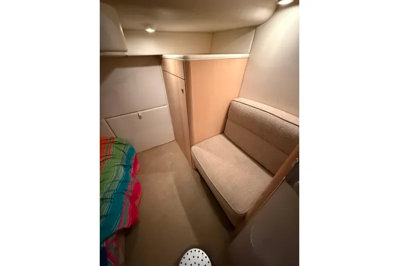 Slide: The Image of Interior of 1998 Bayliner 3685 Avanti Sunbridge, featuring cozy seating and colorful bedding. - 12