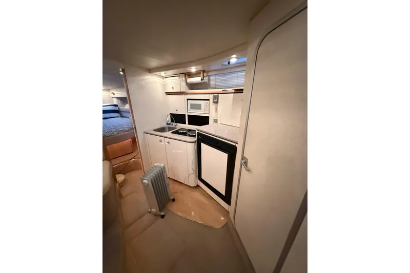 Slide: The Image of 1998 Bayliner 3685 Avanti Sunbridge interior with kitchenette and cozy sleeping area. - 14