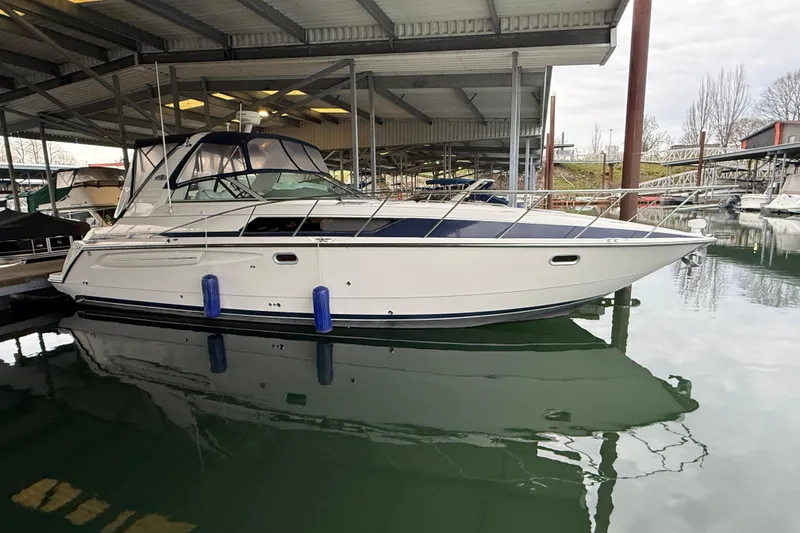 Slide: The Image of 1998 Bayliner 3685 Avanti Sunbridge docked in a marina under a covered shelter. - 40
