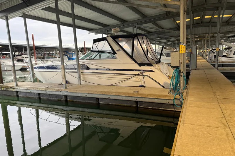 Slide: The Image of 1998 Bayliner 3685 Avanti Sunbridge docked in a covered marina slip. - 41