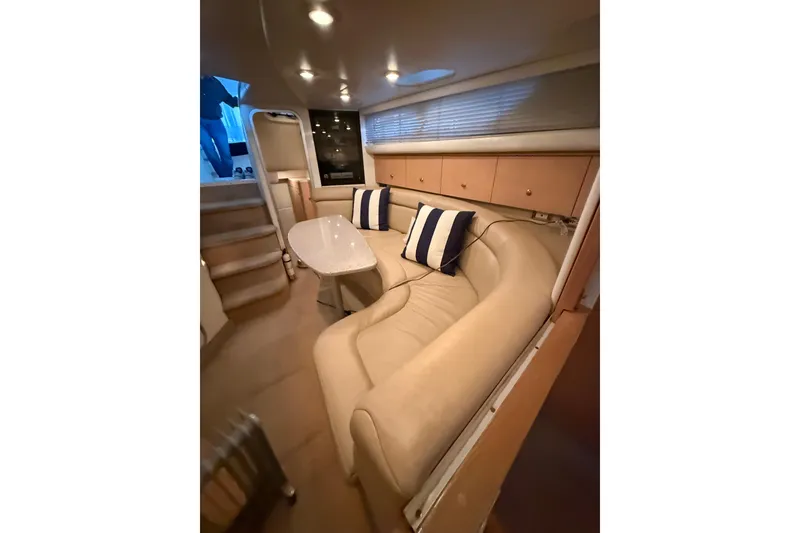 Slide: The Image of Interior of 1998 Bayliner 3685 Avanti Sunbridge with beige seating and striped cushions. - 6