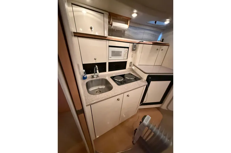 Slide: The Image of Compact kitchen in 1998 Bayliner 3685 Avanti Sunbridge with sink, stove, and microwave. - 9