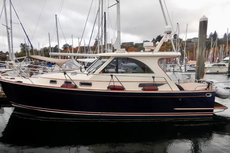 Slide: The Image of 2007 Legacy Yachts 32 docked in a marina, surrounded by sailboats. - 2