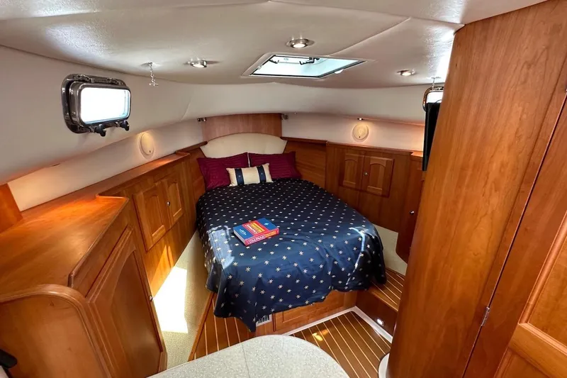 Slide: The Image of Luxurious 2007 Legacy Yachts 32 cabin interior with cozy bed and wooden cabinetry. - 5
