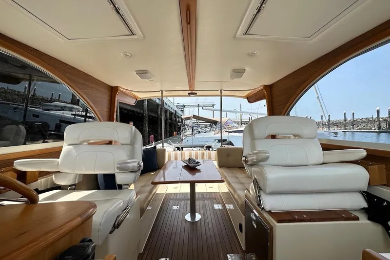 Slide: The Image of Interior of 2007 Legacy Yachts 32, featuring elegant seating and wooden accents. - 7