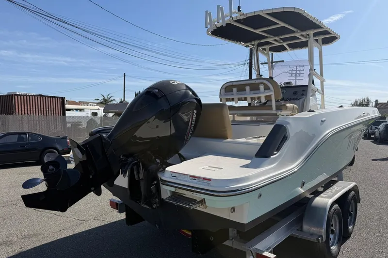 Slide: The Image of 2022 2 Bar T22 CX boat with outboard motor on trailer, parked outdoors. - 4