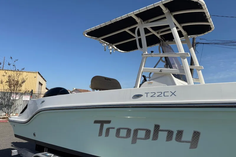 Slide: The Image of 2022 2 Bar T22 CX boat with T-top, parked outdoors under clear blue sky. - 10