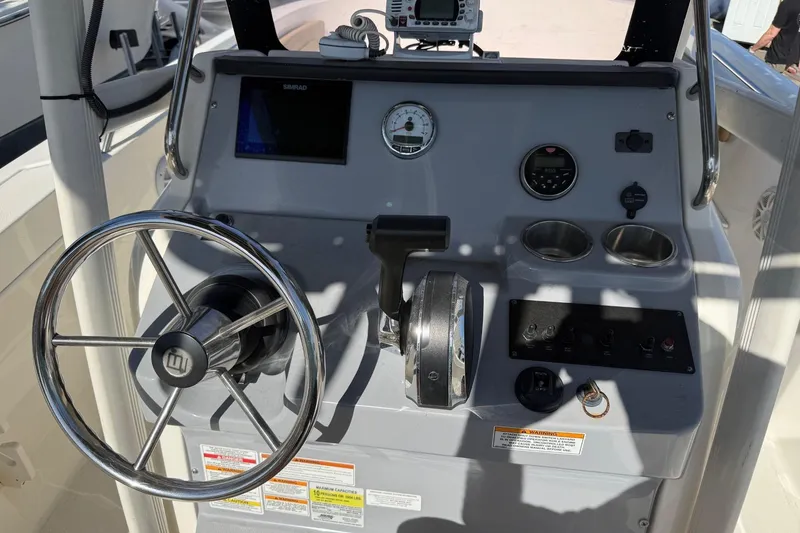 Slide: The Image of 2022 2 Bar T22 CX boat dashboard with steering wheel and control panel. - 17
