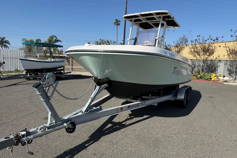 Slide: The Image of 2022 2 Bar T22 CX boat on trailer in sunny outdoor setting. - 19
