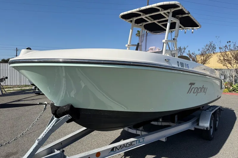Slide: The Image of 2022 2 Bar T22 CX boat on trailer, displayed outdoors under clear sky. - 22