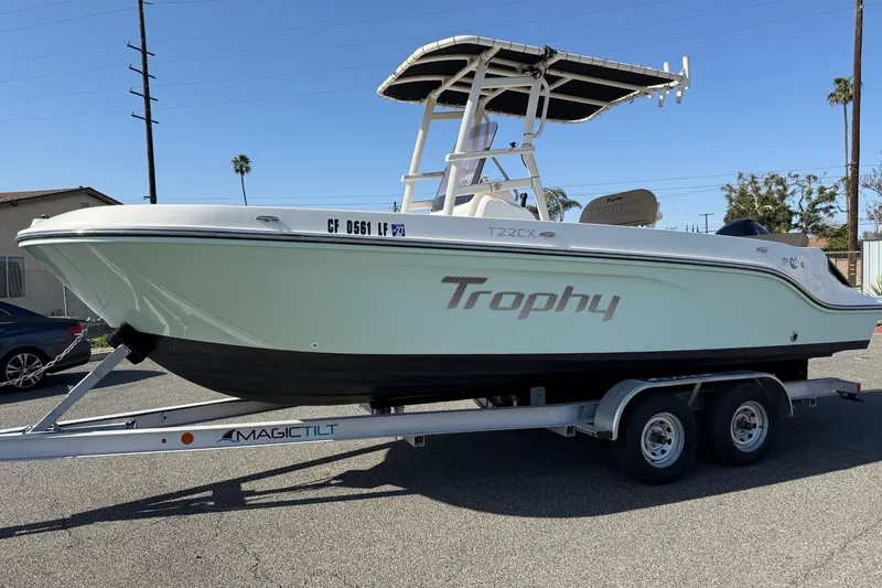 Slide: The Image of 2022 2 Bar T22 CX Trophy boat on trailer, parked outdoors. - 24