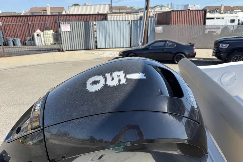 Slide: The Image of Outboard motor on a 2022 2 Bar T22 CX boat, parked near industrial area. - 5