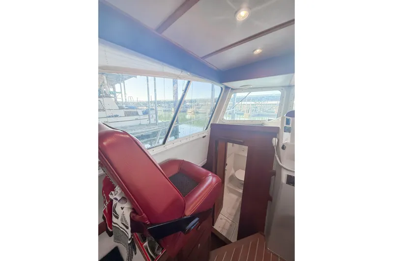 Slide: The Image of 2003 SeaSport Pacific 3200 interior with red seating and cabin view. - 13