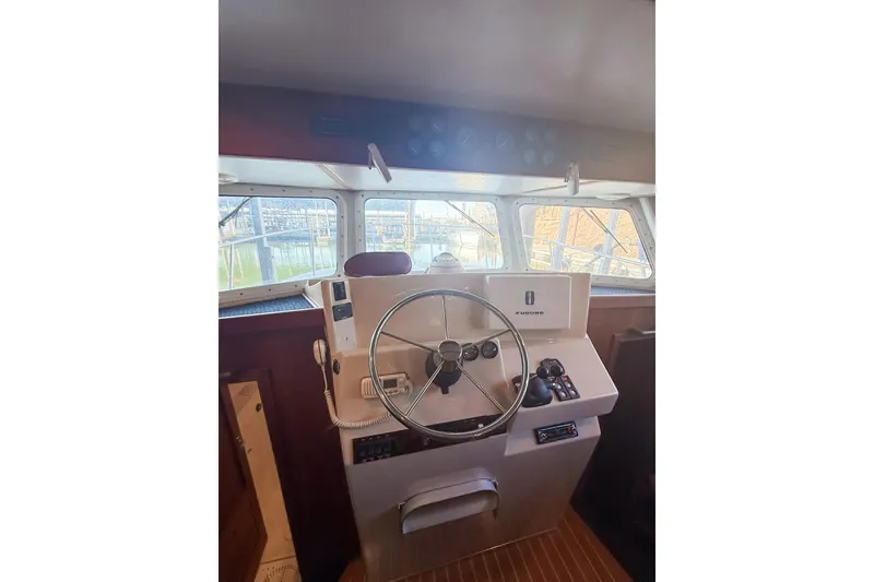 Slide: The Image of 2003 SeaSport Pacific 3200 helm with steering wheel and navigation controls. - 15