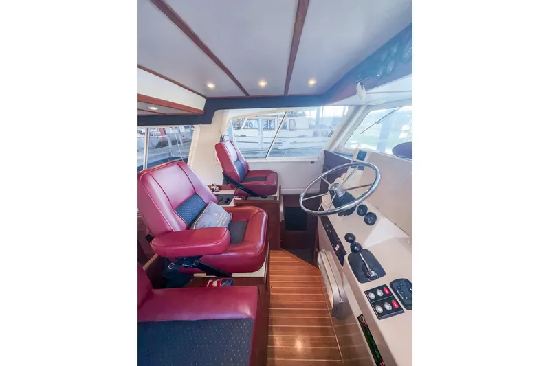 Slide: The Image of 2003 SeaSport Pacific 3200 interior with red seats and steering wheel. - 16