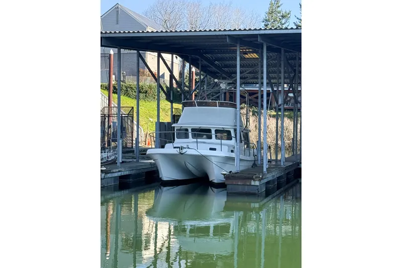 Slide: The Image of 2003 SeaSport Pacific 3200 boat docked under a covered marina. - 2