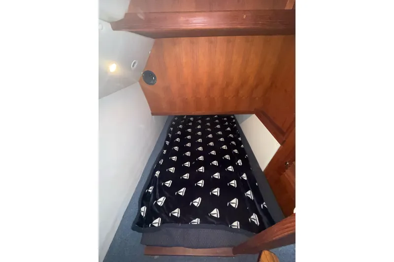 Slide: The Image of 2003 SeaSport Pacific 3200 cabin interior with a cozy bed and nautical-themed blanket. - 20