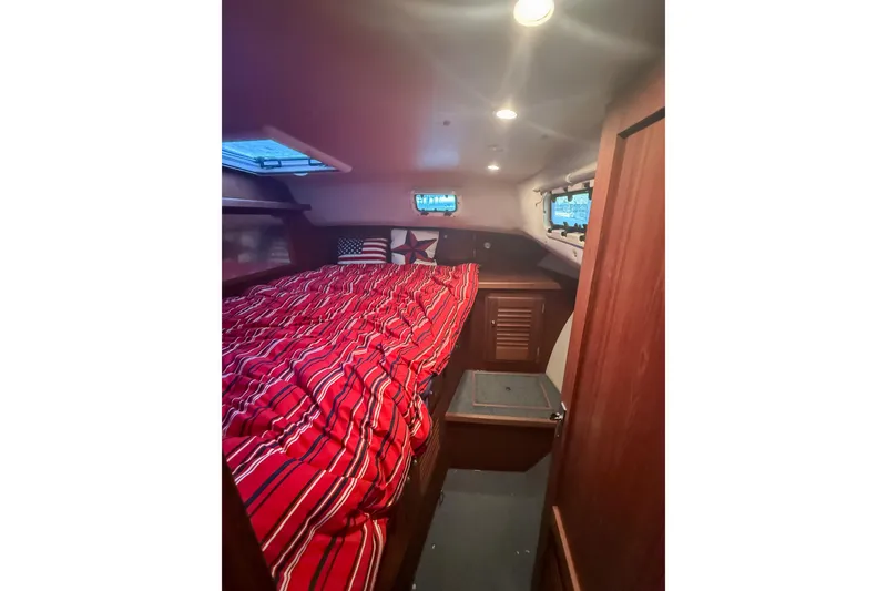 Slide: The Image of 2003 SeaSport Pacific 3200 cabin interior with red-striped bedding and wooden cabinetry. - 22