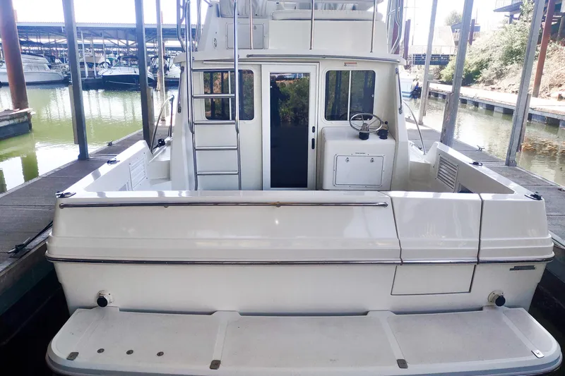 Slide: The Image of 2003 SeaSport Pacific 3200 boat docked, rear view showing deck and cabin entrance. - 25