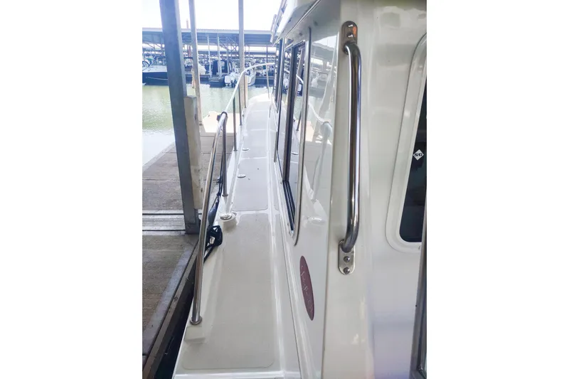 Slide: The Image of 2003 SeaSport Pacific 3200 boat docked, side view with railing and windows. - 27