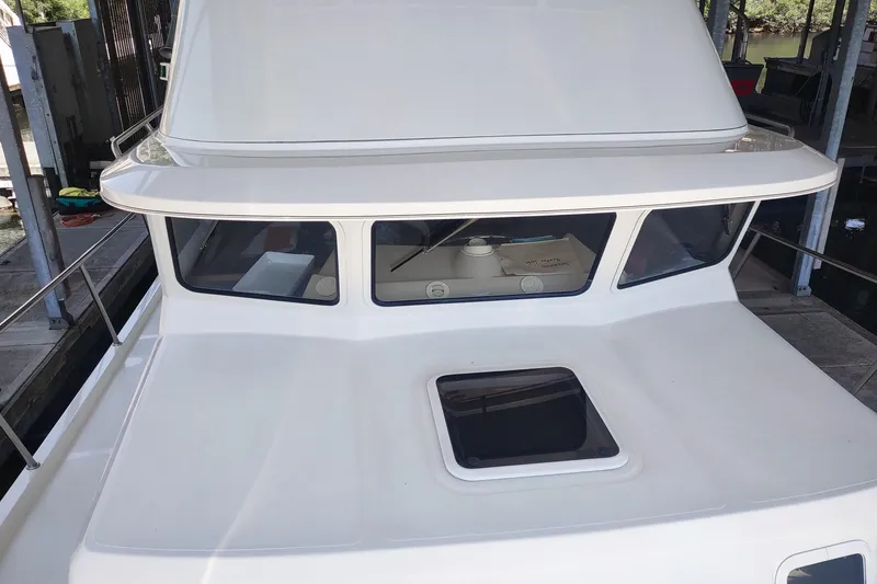 Slide: The Image of 2003 SeaSport Pacific 3200 boat, white exterior, docked in a marina. - 28