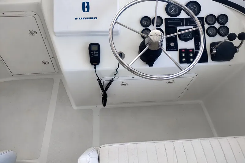 Slide: The Image of 2003 SeaSport Pacific 3200 boat helm with steering wheel and control panel. - 29