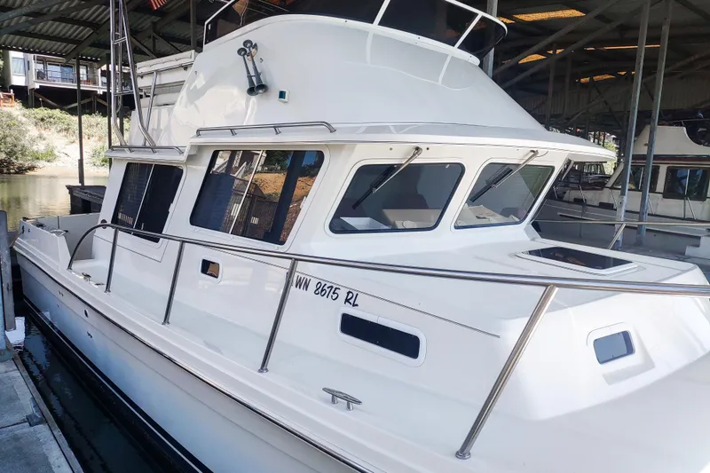 Slide: The Image of 2003 SeaSport Pacific 3200 boat docked in a marina under a covered structure. - 3