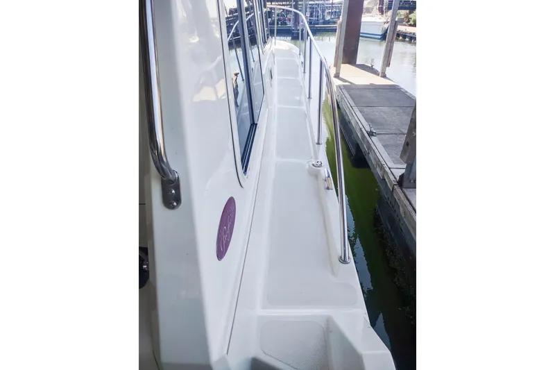 Slide: The Image of 2003 SeaSport Pacific 3200 boat docked, side view with railing and windows. - 31