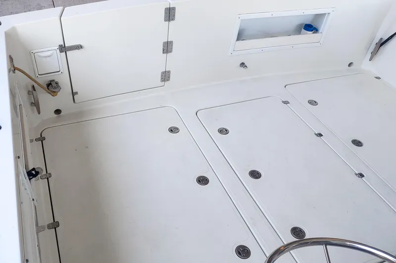 Slide: The Image of 2003 SeaSport Pacific 3200 boat deck with storage compartments and clean white surface. - 32