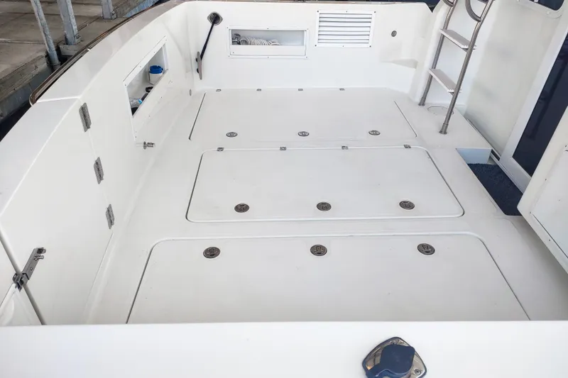 Slide: The Image of 2003 SeaSport Pacific 3200 boat deck with storage compartments and ladder. - 33